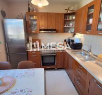 A kitchen in a 3-room apartment with a wooden decor and a dining table.