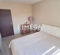 A bedroom in a 3-room apartment with a wooden decor floor, a bed, and cabinets.