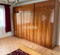Bedroom with wood-patterned flooring and a built-in wardrobe in a family house.