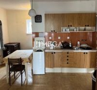 A kitchen in a family house with a wooden decor floor and older furniture.