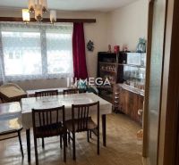 Dining room of a family house with a wooden decor floor, dining table, and display cabinet.
