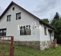 A family house in Zboj with a stone foundation and a garden, surrounded by greenery.