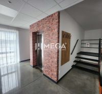 A hallway in an office with an elevator, staircase, and a hanging wall with hooks.