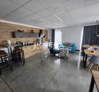 Offices with polished concrete flooring, stylish furniture, and decorative wooden paneling.