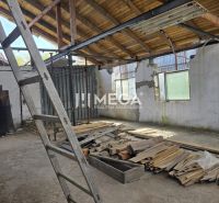 Interior of a family house with an unfinished roof, a ladder, and a pile of wood on the floor.