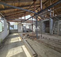 The interior of an unfinished family house with exposed wooden roof structure and unplastered walls.