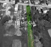 Land for sale in the village of Senné, designated for residential use, surrounded by greenery.