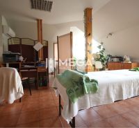 Massage room with a bed and an office desk, floor with wooden decor.