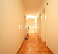 A corridor in commercial premises with tiles and white walls.