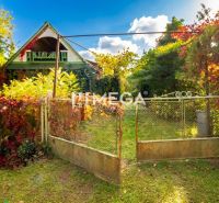 A family house in Petrovce surrounded by greenery and a garden with a gate.