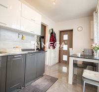 A kitchen in a family house with white and gray cabinets and a dining table.