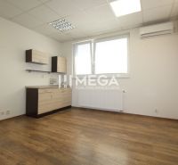 An office with white walls, wooden floor decor, and storage space.