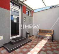 A courtyard in office premises on Sama Chalupka Street in Michalovce with a bench and paving.