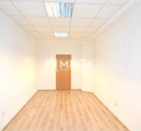 An office with a wooden floor, white walls, and ceiling lighting.