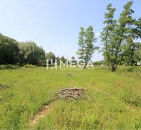 A residential plot in the village of Ptičie, surrounded by greenery and blue skies.