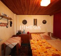 A traditional room in a cottage with a wooden ceiling and decorative elements on the walls.
