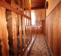 Wooden wall paneling in the hallway of the cottage with decorative curtains.