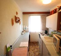 A cozy kitchen in a cottage with simple equipment and wall decorations.
