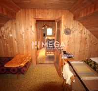 Wooden wall cladding, seating area, and simple beds in the cabin.