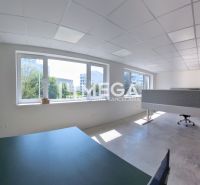 Bright office spaces with large windows and concrete flooring.