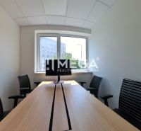 Office interior with a long table, four chairs, and a window.
