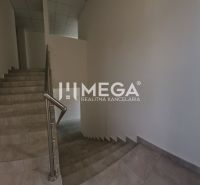 A staircase in offices with a tiled floor and a window providing natural light.