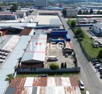 The area of warehouses and halls on Fidlikova Street in Humenné with parking and facilities.