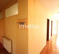 A corridor of offices with tiles and a heating element.