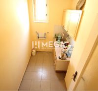 A small kitchenette in an office with white walls and a perforated floor.