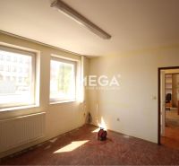 Offices with double windows and wooden decor flooring, entrance to work desks.