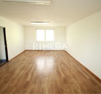 An office interior with wood-patterned flooring and a large window.