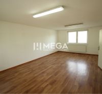 Spacious offices with wood-patterned flooring, white walls, and windows.