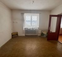 A room in a family house with a wooden decor floor and paintings leaning against the wall.