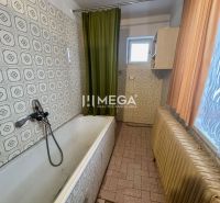 A bathroom in a family house with a bathtub and decorated tiles.