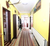 A hallway in a family house with a radiator, carpets, and wall decorations.