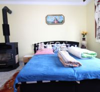 Interior of a family house with a bed, stove, and colorful accessories.