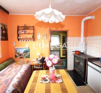 A family house with orange walls, a tiled stove, and decorations, cozy interior.