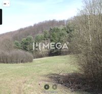 Agricultural and forest land in Maškovce with a view of wooded hills.