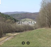 The landscape of Maškovce with agricultural and forest lands surrounded by hills and forests.