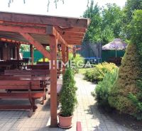 Vranov nad Topľou, Budovateľská: Gastro premises with wooden seating and greenery on the terrace.