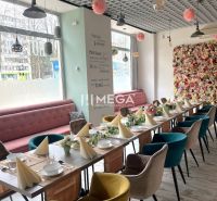 Gastro premises with a decorated table, flower wall, and floor with wooden decor.