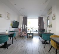 Gastro premises with colorful chairs and a wooden decor floor.