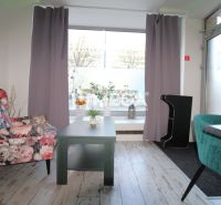 Interior with wood-patterned flooring, flowers, chairs in a dining area.