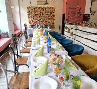 Interior of dining spaces with a decorative wall and a set table with colorful napkins.