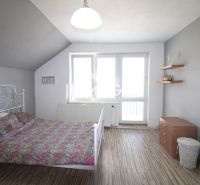 Interior of a family house with a bed, wardrobe, and floor with wooden decor.