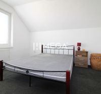 Bedroom in a family house with an iron bed, nightstand, and basket.