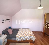 A bedroom in a family house with a bed and a wooden decor floor.