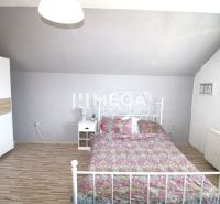 A bedroom in a family house with a metal bed, a wardrobe, and a floor with a wooden decor.