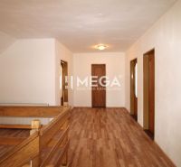 The interior of a family house with a wooden decor floor and wooden railing by the stairs.