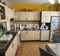 A kitchen in a 4-room apartment with a wooden decor floor and cooking equipment.